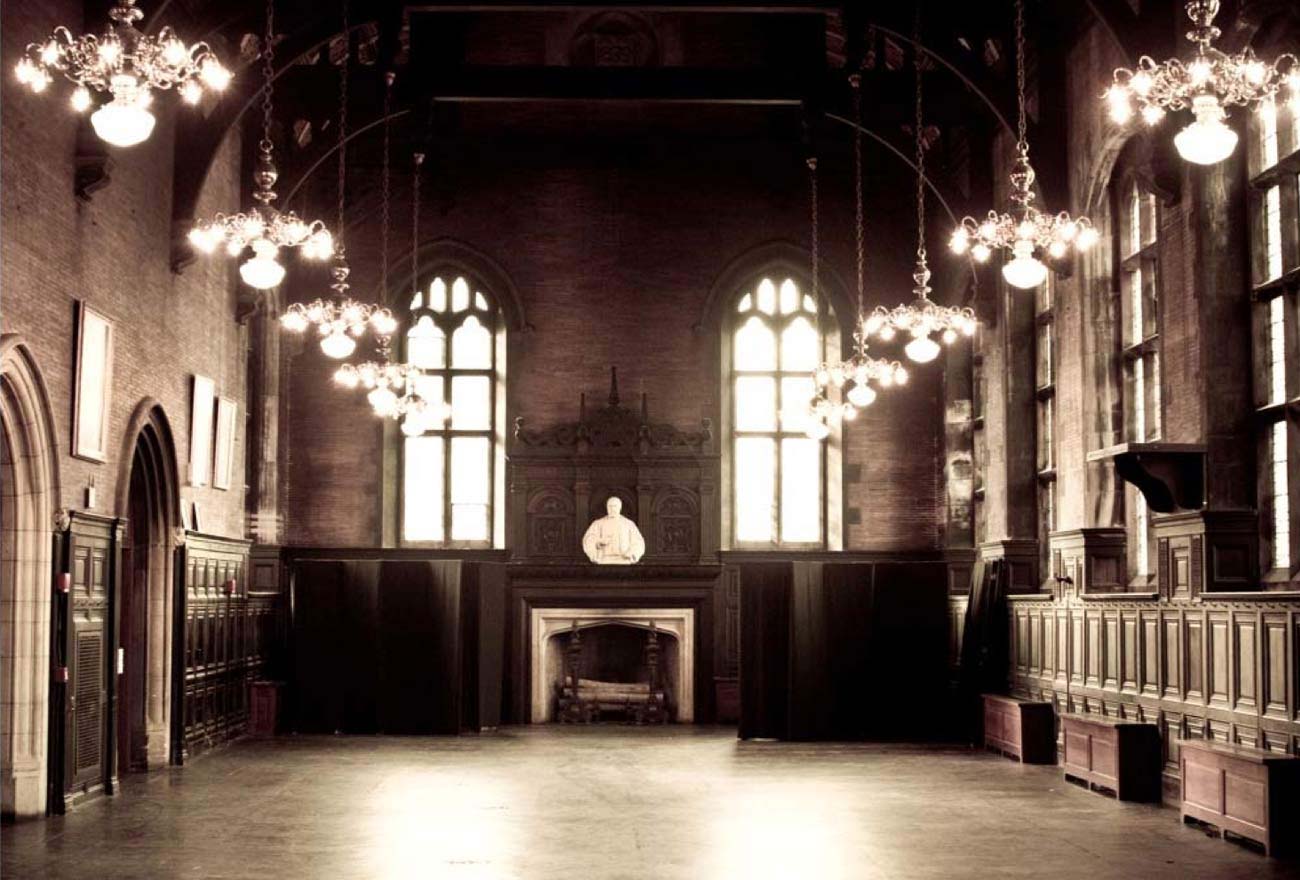 A large, ornate lobby with chandeliers, a fireplace, and a statue above it.